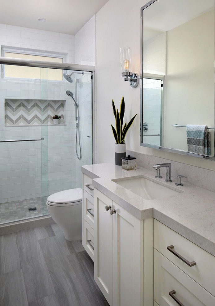 Mid-sized country 3/4 bathroom in San Francisco with shaker cabinets, white cabinets, an alcove shower, a one-piece toilet, white tile, ceramic tile, white walls, porcelain floors, a drop-in sink, laminate benchtops, grey floor, a sliding shower screen and grey benchtops.