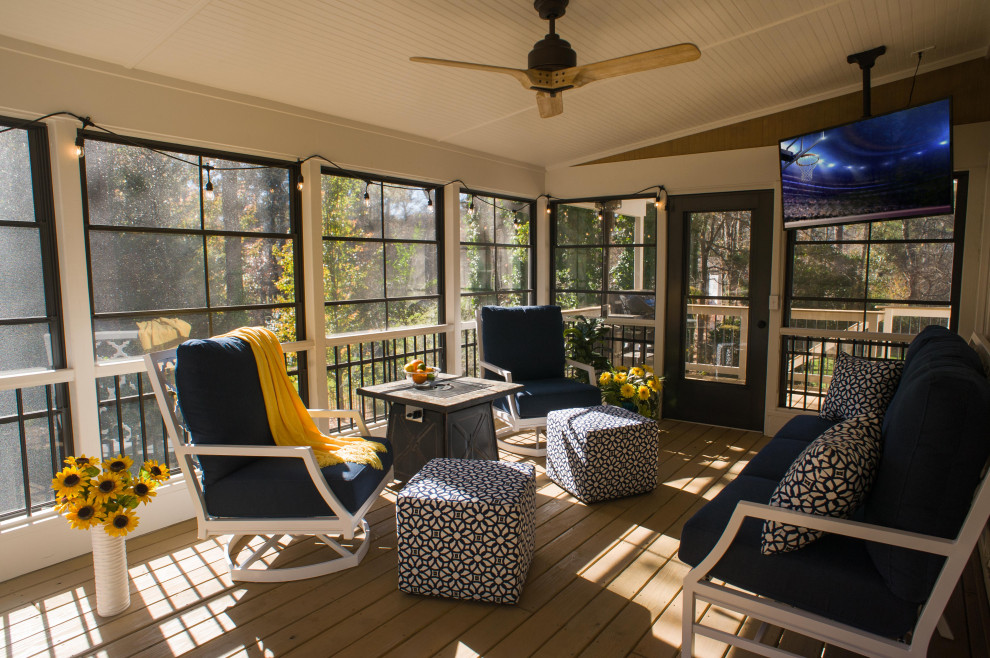Photo of a mid-sized transitional screened-in verandah in Atlanta with a roof extension and mixed railing.