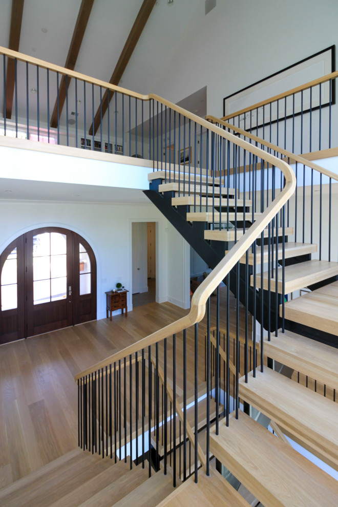 Свежая идея для дизайна: огромная лестница на больцах в стиле модернизм с деревянными ступенями, перилами из смешанных материалов и стенами из вагонки - отличное фото интерьера
