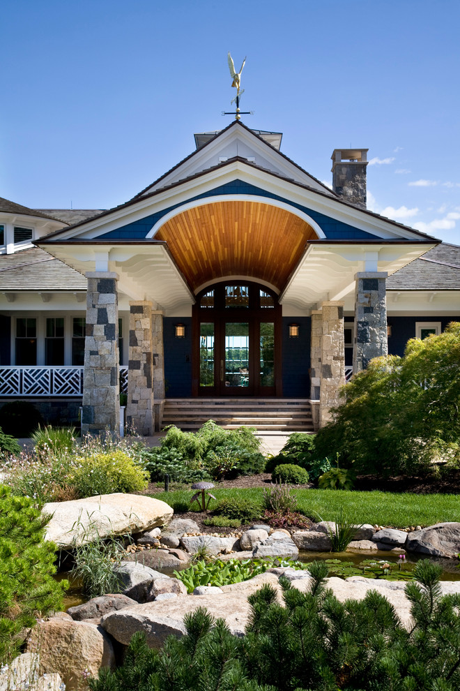 This is an example of an expansive traditional two-storey blue exterior in Boston with wood siding and a hip roof.
