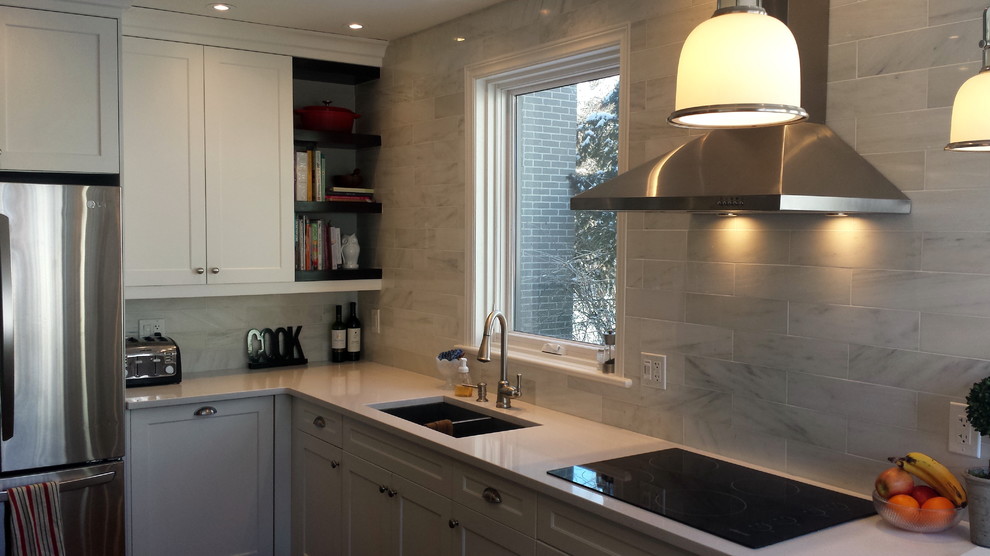 Example of a mid-sized transitional u-shaped dark wood floor enclosed kitchen design in Ottawa with an undermount sink, shaker cabinets, white cabinets, quartz countertops, white backsplash, subway tile backsplash, stainless steel appliances and a peninsula