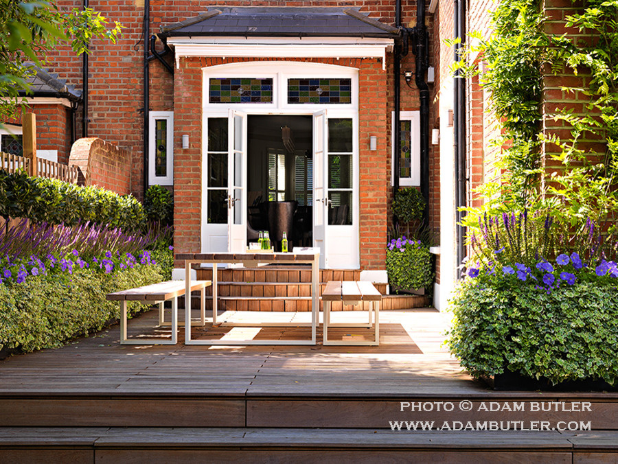 Inspiration for a mid-sized contemporary backyard patio in London with decking.