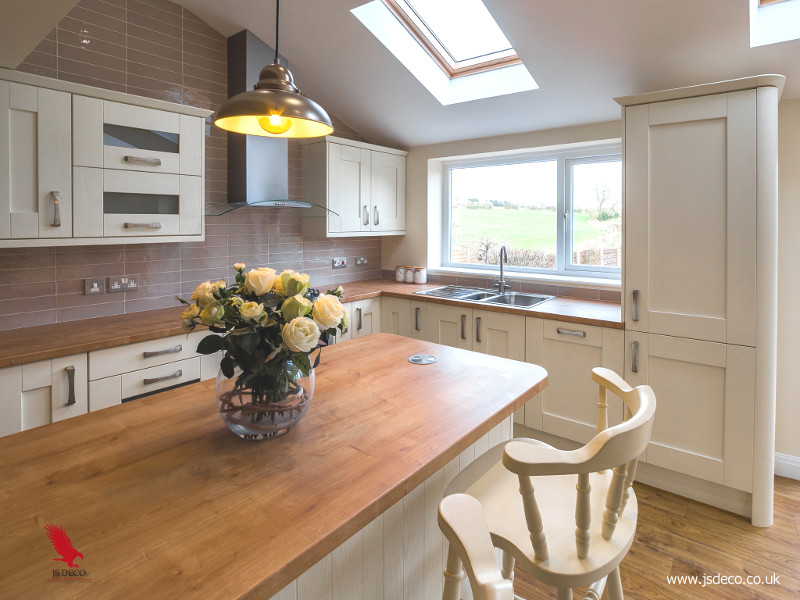 Inspiration for a large country l-shaped open plan kitchen in Other with a triple-bowl sink, shaker cabinets, beige cabinets, laminate benchtops, grey splashback, porcelain splashback, panelled appliances, laminate floors, with island and multi-coloured floor.