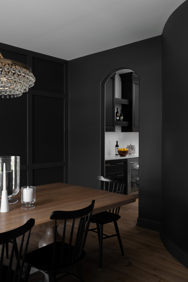 Imagen de comedor clásico grande cerrado con paredes negras, suelo de madera clara y boiserie