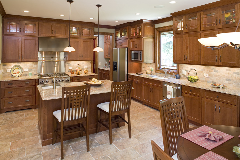 Photo of a large arts and crafts l-shaped separate kitchen in Chicago with an undermount sink, shaker cabinets, medium wood cabinets, granite benchtops, beige splashback, stone tile splashback, stainless steel appliances and ceramic floors.