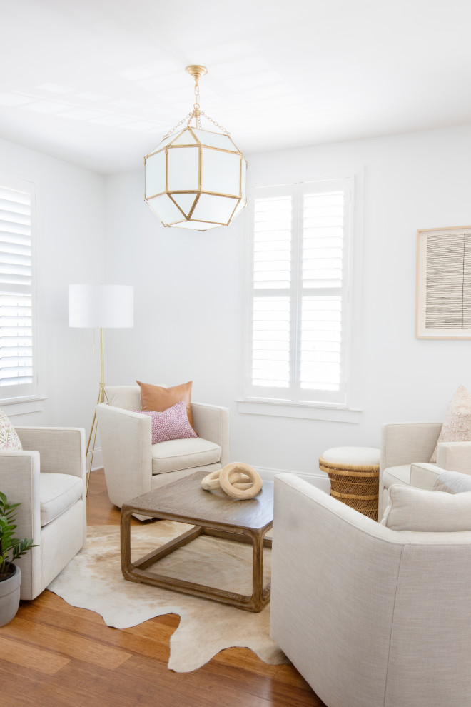 This is an example of a mid-sized transitional formal open concept living room in Charleston with white walls, medium hardwood floors, no tv and brown floor.