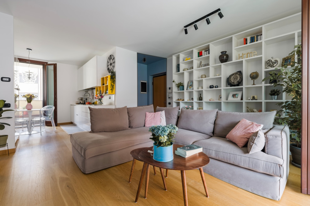 Foto di un soggiorno contemporaneo di medie dimensioni e aperto con libreria, pareti bianche, parquet chiaro, parete attrezzata e pavimento beige