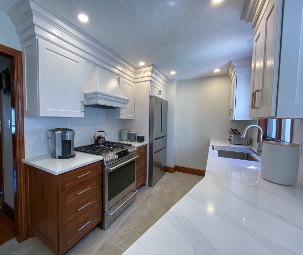 Example of a small transitional galley eat-in kitchen design in Boston with a drop-in sink, shaker cabinets, white cabinets, quartzite countertops, white backsplash, glass tile backsplash, stainless steel appliances, no island and white countertops