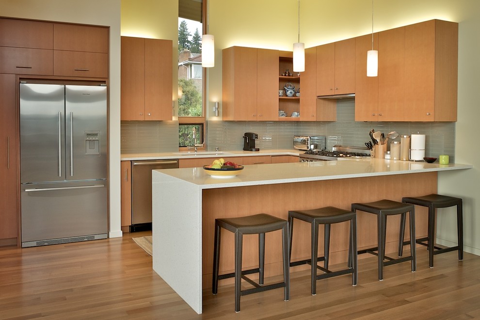 Design ideas for a contemporary u-shaped kitchen in Seattle with an undermount sink, flat-panel cabinets, medium wood cabinets, grey splashback and stainless steel appliances.