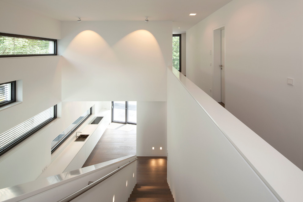 This is an example of a contemporary wood straight staircase in Cologne with wood risers.
