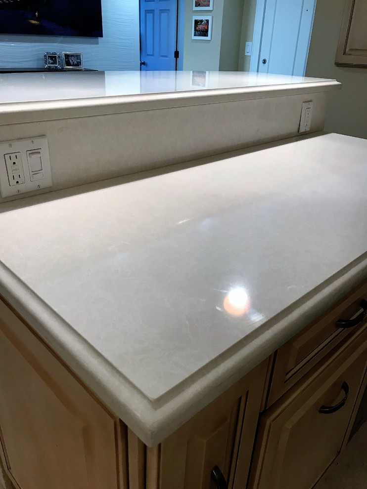 Photo of a mid-sized transitional l-shaped eat-in kitchen in Other with an undermount sink, raised-panel cabinets, beige cabinets, quartz benchtops, beige splashback, travertine splashback, stainless steel appliances, travertine floors, with island and beige floor.