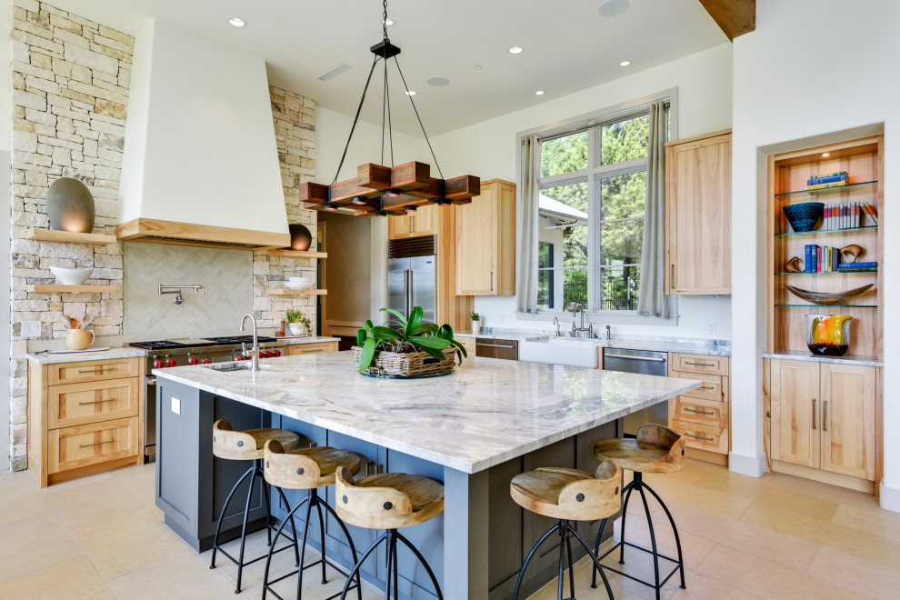 Photo of a transitional l-shaped kitchen in Austin with a farmhouse sink, shaker cabinets, light wood cabinets, multi-coloured splashback, stainless steel appliances, with island, beige floor and multi-coloured benchtop.