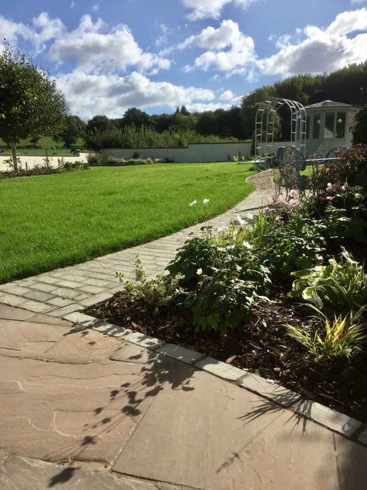 Geometrischer, Mittelgroßer Klassischer Gartenweg im Sommer, hinter dem Haus mit direkter Sonneneinstrahlung, Natursteinplatten und Steinzaun in Sonstige