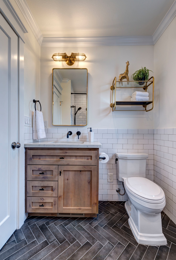 Small country kids bathroom in San Francisco with shaker cabinets, medium wood cabinets, an alcove tub, a shower/bathtub combo, a two-piece toilet, white tile, porcelain tile, white walls, porcelain floors, a drop-in sink, engineered quartz benchtops, black floor, a shower curtain and white benchtops.