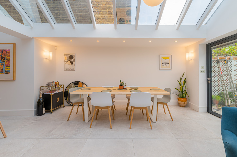 Immagine di una grande sala da pranzo aperta verso il soggiorno minimal con pavimento in gres porcellanato e pavimento grigio