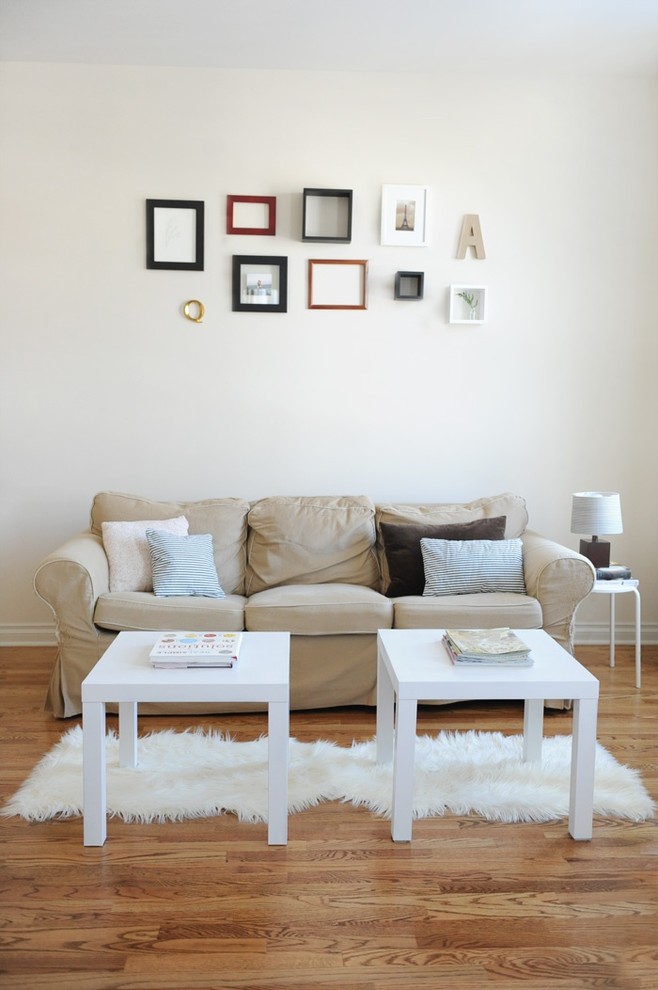 Inspiration for an eclectic living room in Other with white walls and medium hardwood floors.