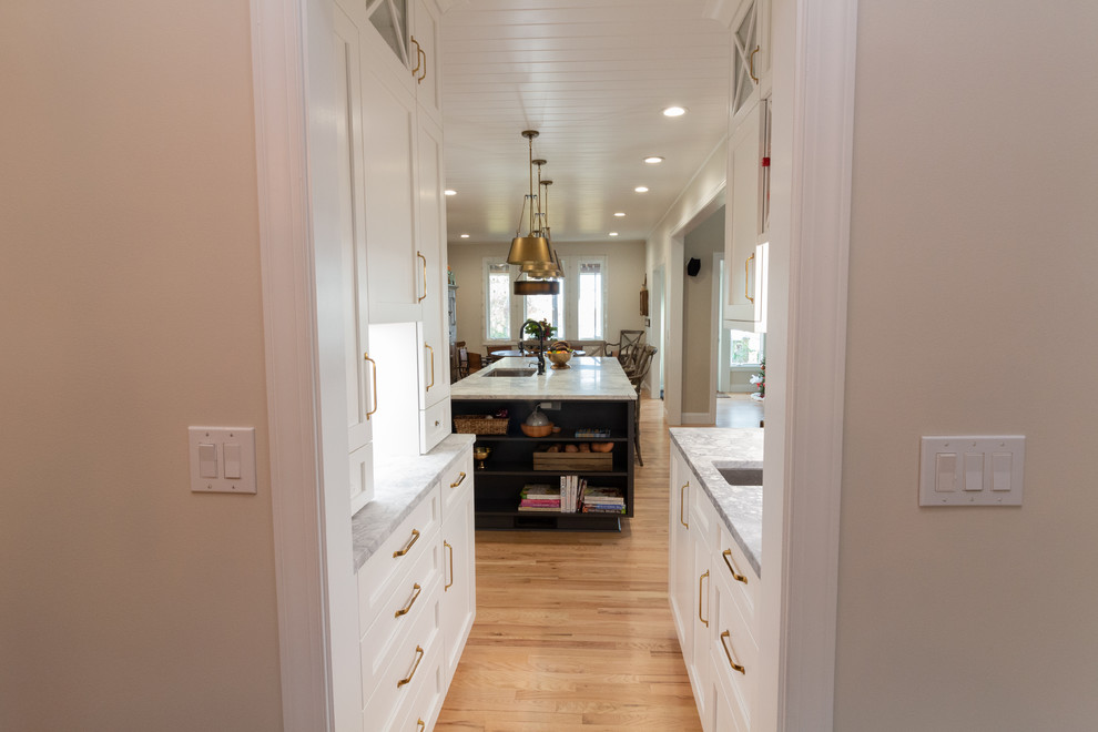 Eat-in kitchen - large l-shaped eat-in kitchen idea with shaker cabinets, white cabinets, granite countertops, an island and white countertops