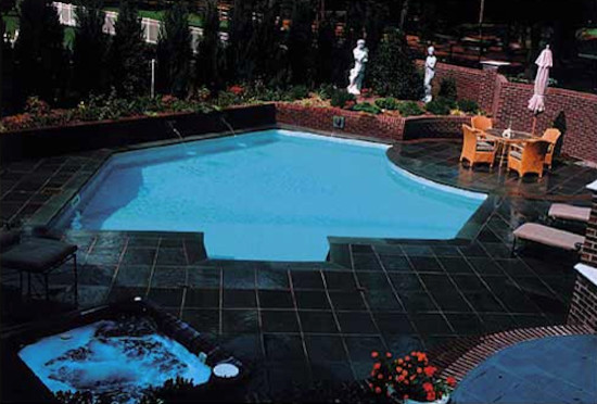 Example of a backyard stone and custom-shaped pool design