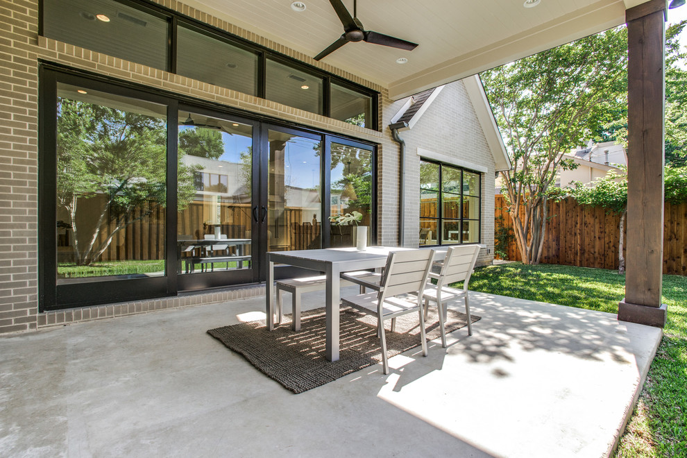 Mid-sized transitional backyard verandah in Dallas with a fire feature, concrete slab and a roof extension.