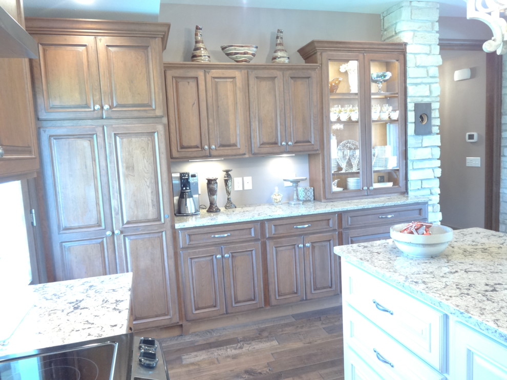 Inspiration for a large single-wall open concept kitchen remodel with an undermount sink, raised-panel cabinets, medium tone wood cabinets, quartzite countertops, stainless steel appliances and an island