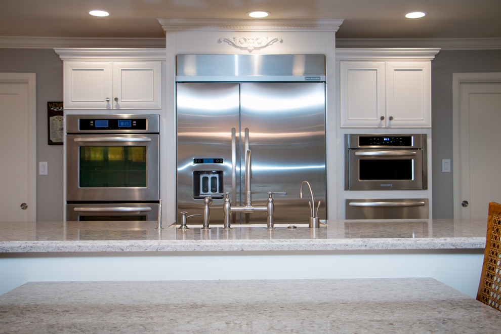 Inspiration for a huge transitional open concept kitchen remodel with a farmhouse sink, recessed-panel cabinets, white cabinets, quartz countertops, beige backsplash, stone tile backsplash, stainless steel appliances and an island