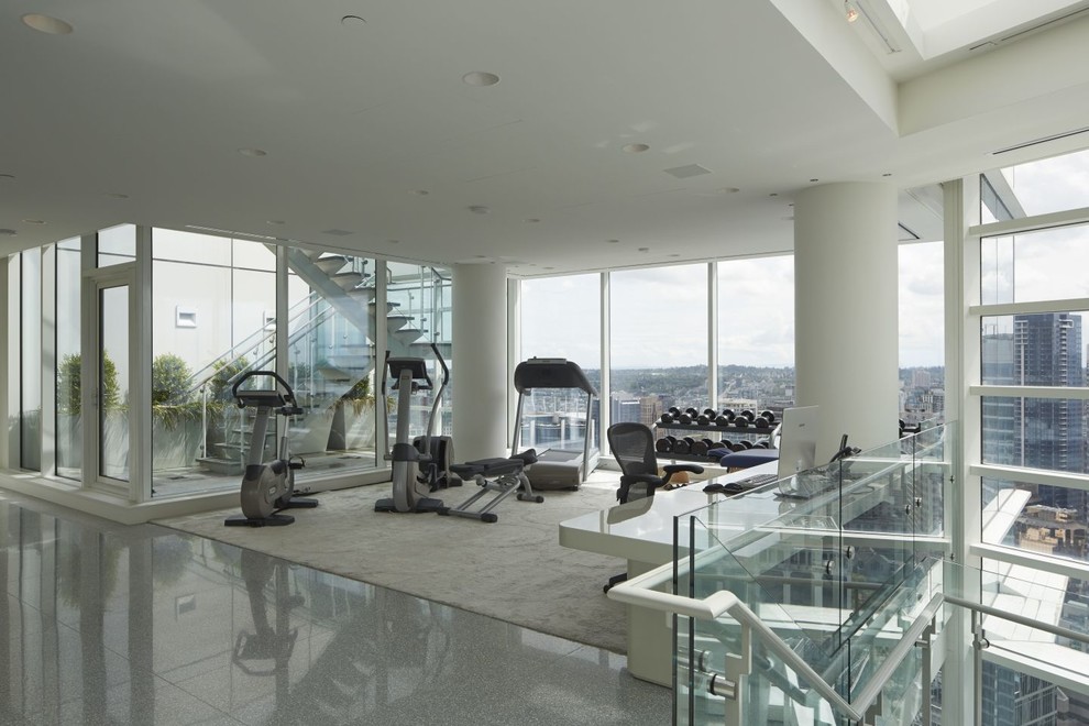 This is an example of an expansive contemporary home weight room in Vancouver with white walls, carpet and grey floor.