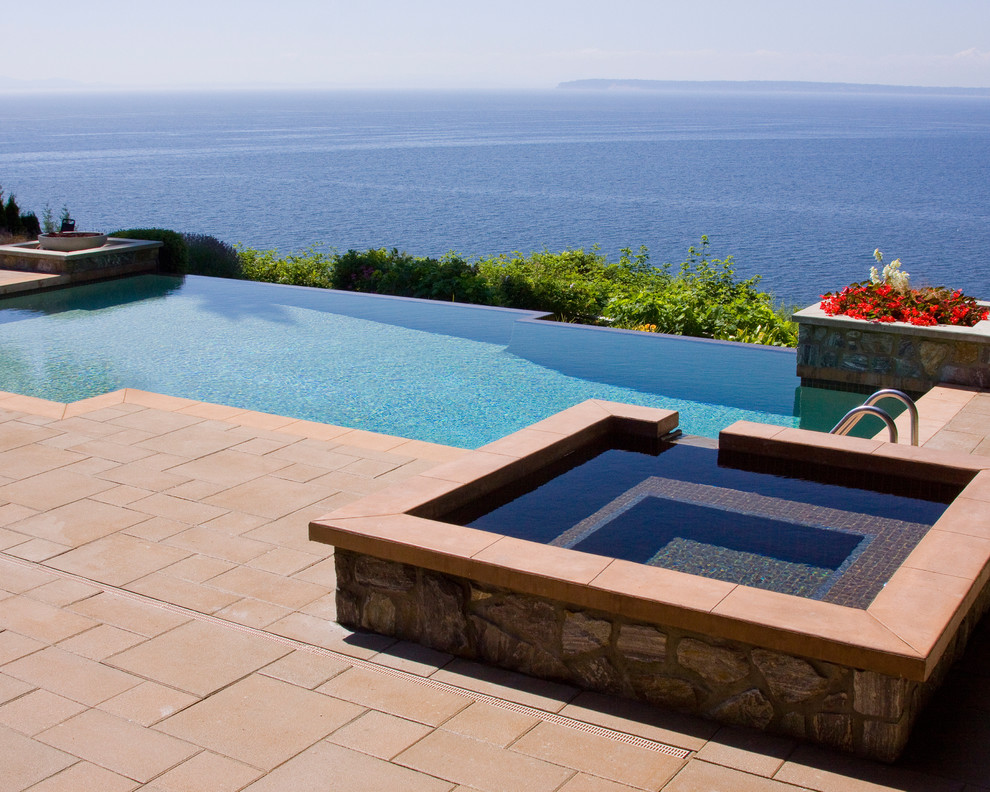 Inspiration for a contemporary backyard custom-shaped infinity pool in Vancouver with a hot tub.
