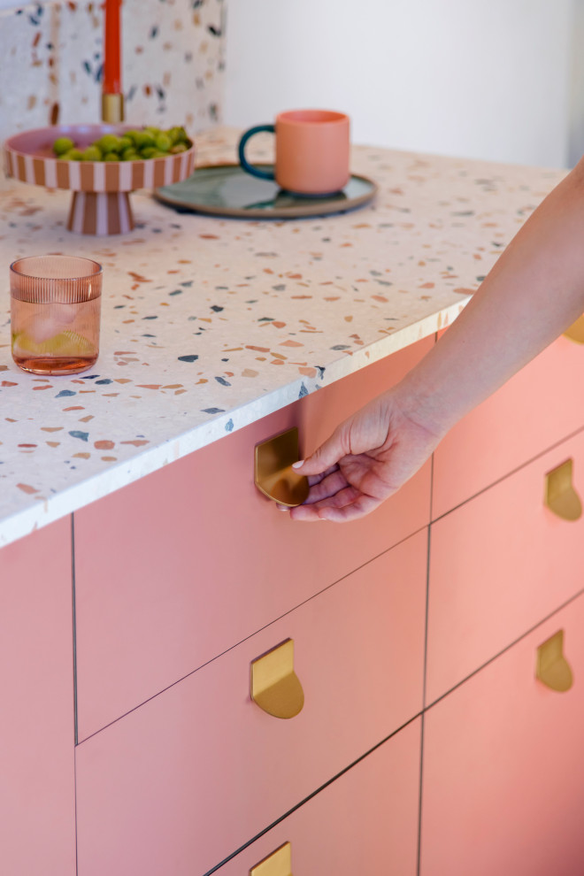 Small mediterranean grey and pink single-wall open plan kitchen in Gloucestershire with a single-bowl sink, flat-panel cabinets, pink cabinets, terrazzo worktops, multi-coloured splashback, marble splashback, light hardwood flooring, no island, multicoloured worktops and feature lighting.