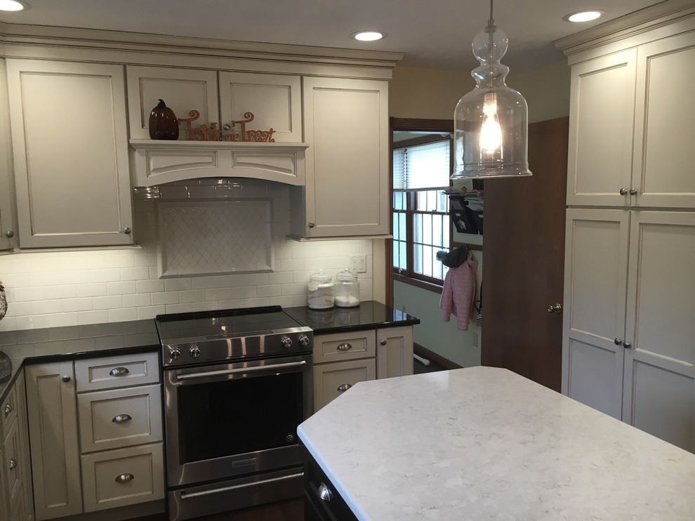 Eat-in kitchen - large transitional medium tone wood floor and brown floor eat-in kitchen idea with an undermount sink, flat-panel cabinets, white cabinets, granite countertops, white backsplash, porcelain backsplash, stainless steel appliances and an island