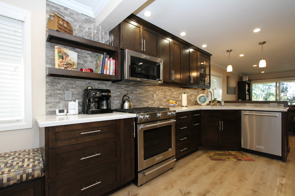 Inspiration for a small transitional l-shaped light wood floor and beige floor open concept kitchen remodel in Orange County with an undermount sink, shaker cabinets, dark wood cabinets, quartz countertops, beige backsplash, glass sheet backsplash, stainless steel appliances and no island