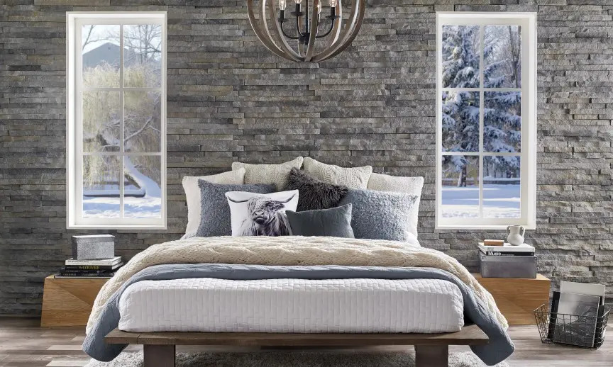Inspiration for a modern master bedroom in New York with grey walls, laminate floors, grey floor and brick walls.