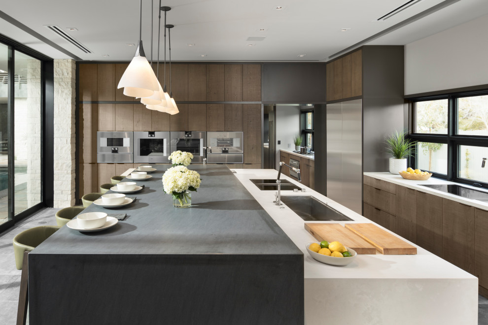 Inspiration for an expansive contemporary l-shaped open plan kitchen in Las Vegas with an undermount sink, flat-panel cabinets, quartz benchtops, stainless steel appliances, porcelain floors, with island, grey floor, white benchtop, medium wood cabinets and window splashback.