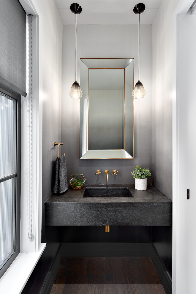 Small transitional powder room in Vancouver with grey walls, an integrated sink, concrete benchtops, brown floor, dark hardwood floors and grey benchtops.