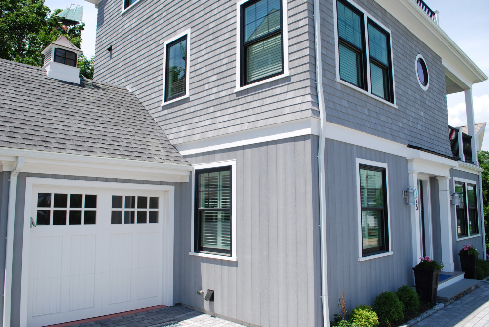 Large beach style three-storey grey house exterior in Providence with wood siding and a gable roof.