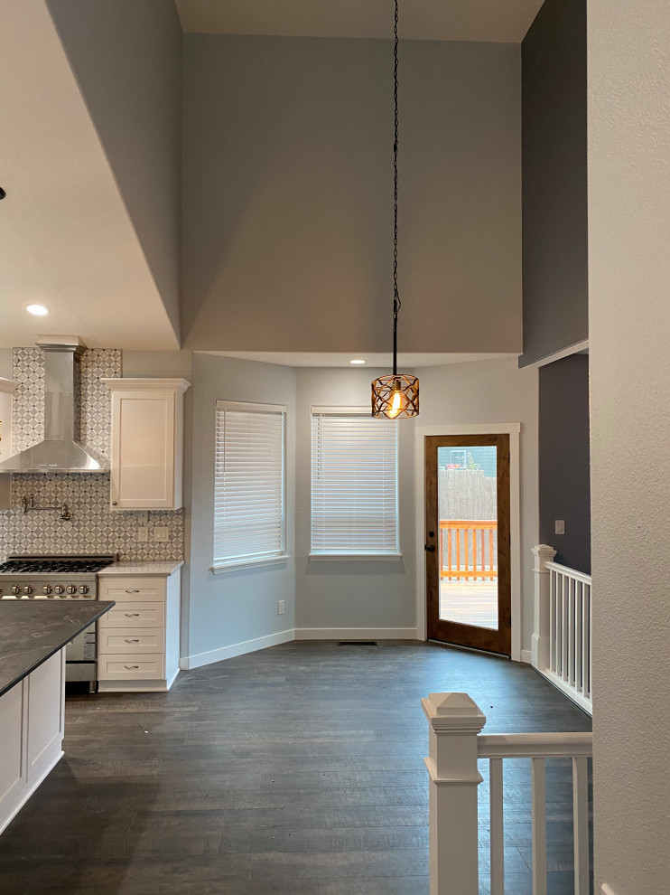 Diseño de comedor abovedado de estilo americano de tamaño medio sin chimenea con con oficina, paredes grises, suelo vinílico y suelo multicolor