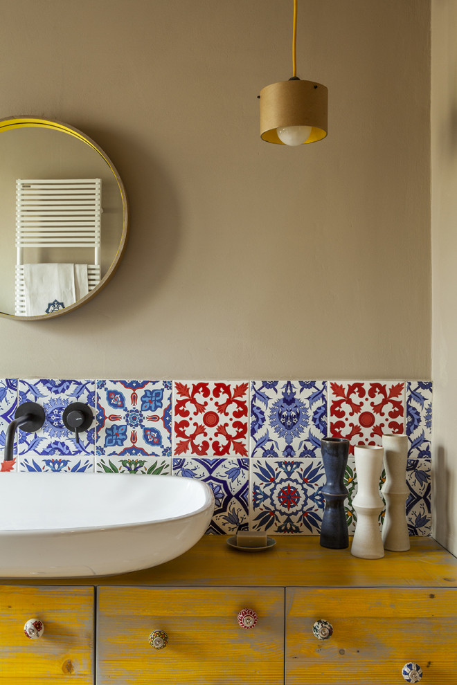 Источник вдохновения для домашнего уюта: ванная комната среднего размера в средиземноморском стиле с фасадами в стиле шейкер, желтыми фасадами, душем в нише, раздельным унитазом, разноцветной плиткой, керамической плиткой, бежевыми стенами, бетонным полом, душевой кабиной, настольной раковиной, столешницей из дерева, бежевым полом, душем с распашными дверями, желтой столешницей, сиденьем для душа, тумбой под одну раковину и подвесной тумбой