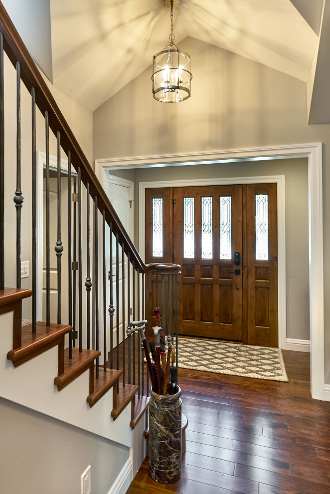 Medium sized traditional foyer in San Francisco with beige walls, medium hardwood flooring, a single front door, a medium wood front door, brown floors and a vaulted ceiling.