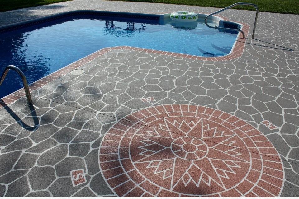 This is an example of a mid-sized traditional backyard l-shaped lap pool in Cincinnati with stamped concrete.