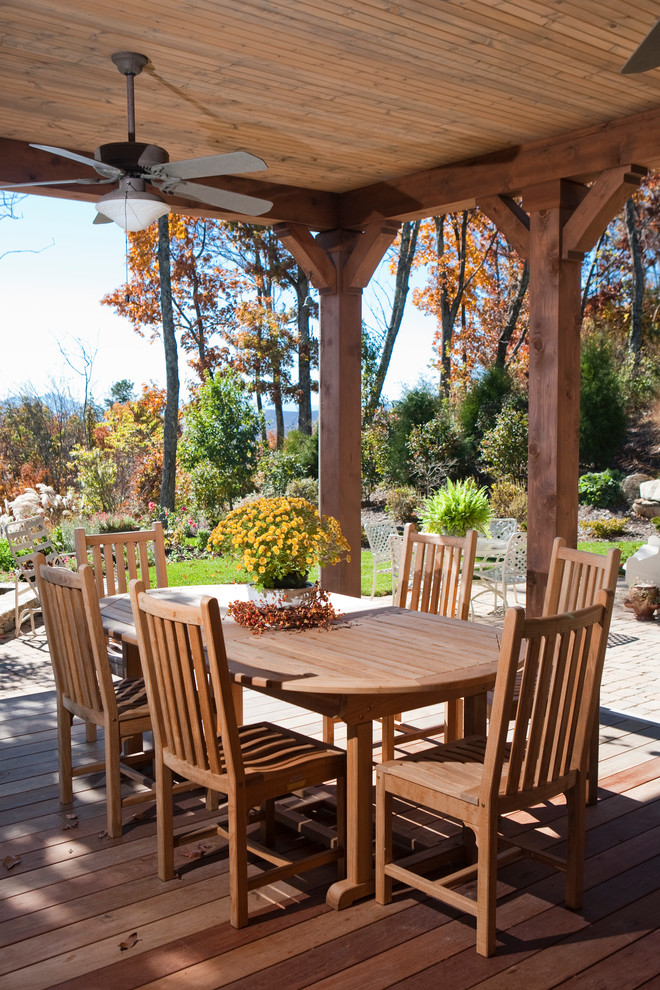 This is an example of a traditional backyard deck in Other with a roof extension.