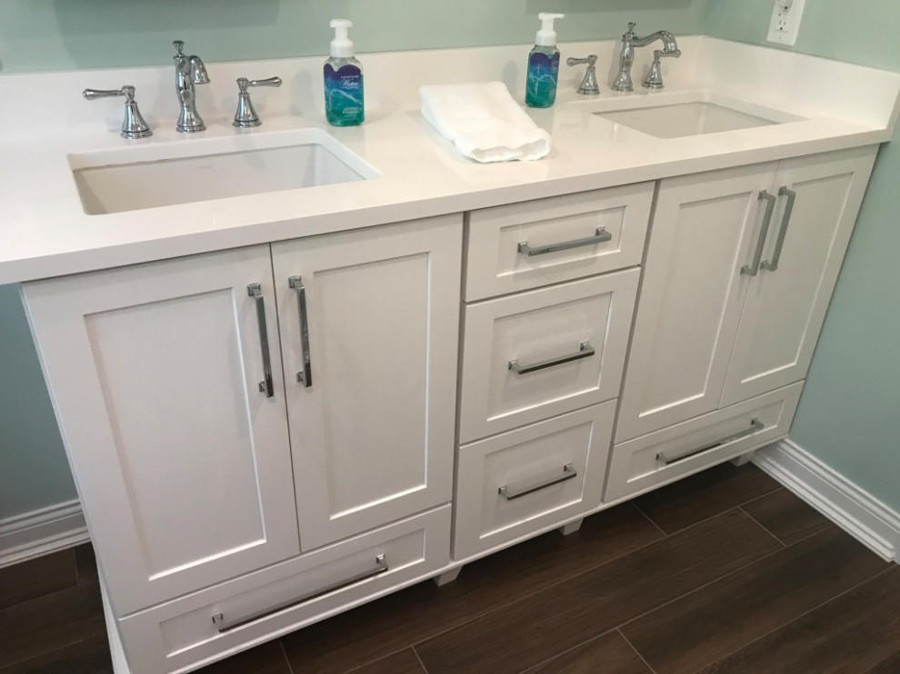 Inspiration for a medium sized coastal family bathroom in Milwaukee with flat-panel cabinets, white cabinets, an alcove bath, a shower/bath combination, a one-piece toilet, white tiles, ceramic tiles, green walls, vinyl flooring, a submerged sink, engineered stone worktops, brown floors, a shower curtain, white worktops, double sinks and a built in vanity unit.