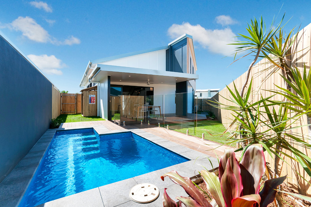 Photo of a small contemporary backyard custom-shaped pool in Cairns with decking.