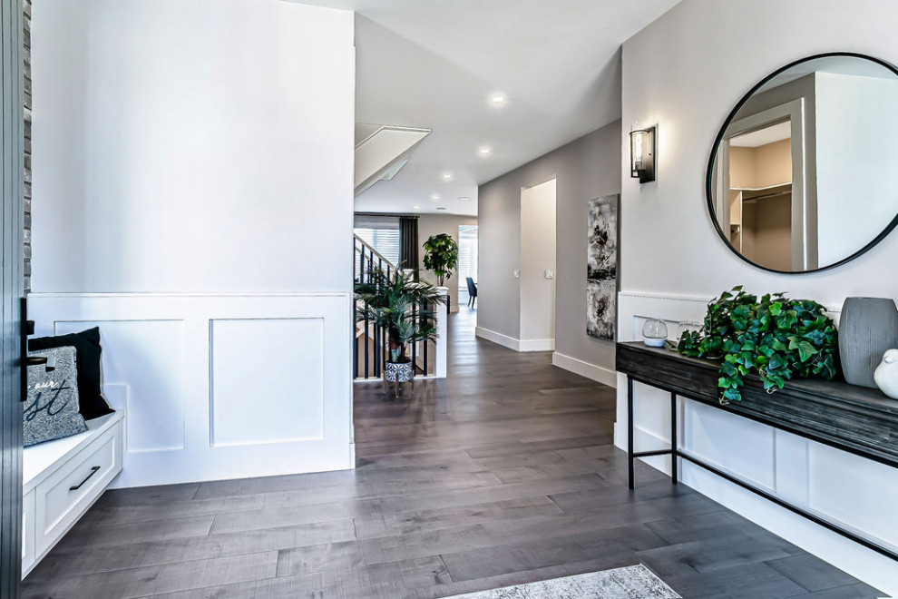 Transitional dark wood floor and gray floor foyer photo in Calgary with white walls and a black front door
