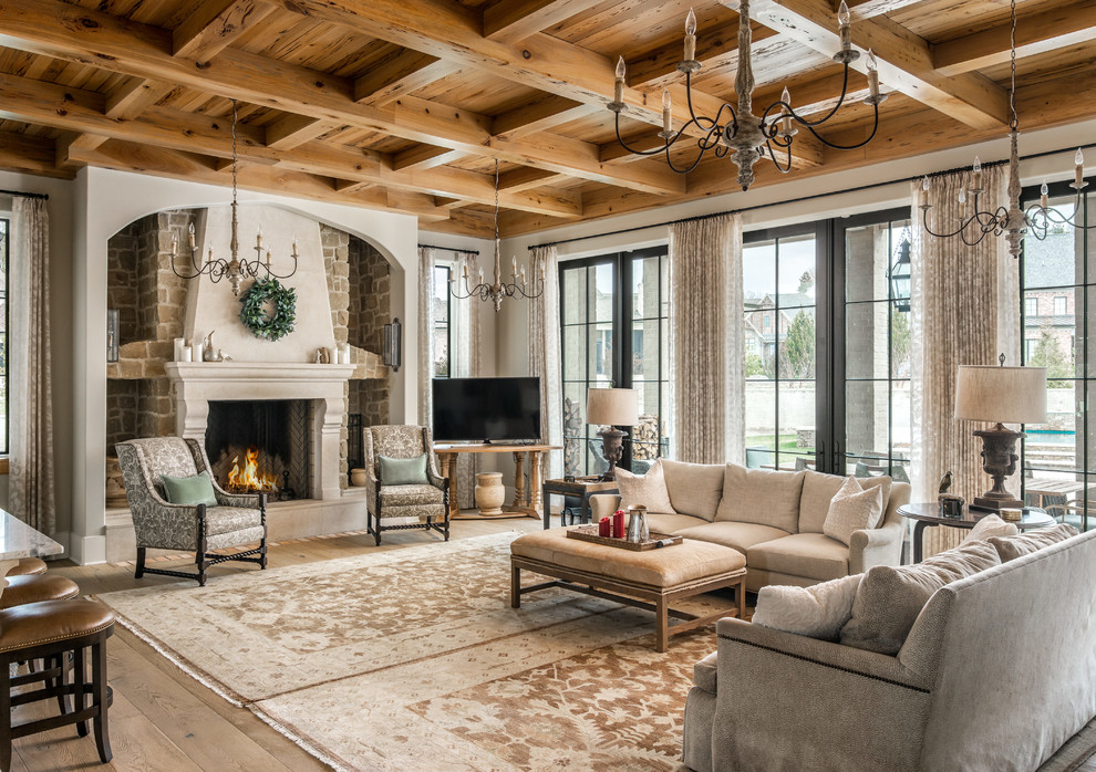 Photo of a large traditional formal open concept living room in Nashville with beige walls, light hardwood floors, a standard fireplace, a stone fireplace surround, a freestanding tv and beige floor.
