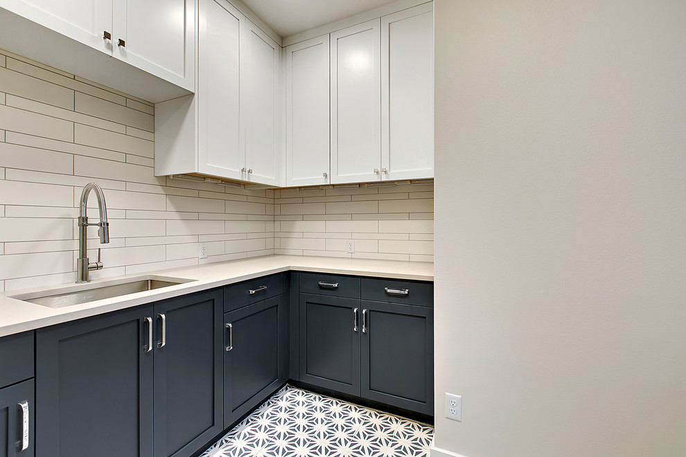 Photo of a mid-sized contemporary u-shaped dedicated laundry room in Austin with an undermount sink, shaker cabinets, blue cabinets, quartz benchtops, white walls, concrete floors, blue floor and white benchtop.