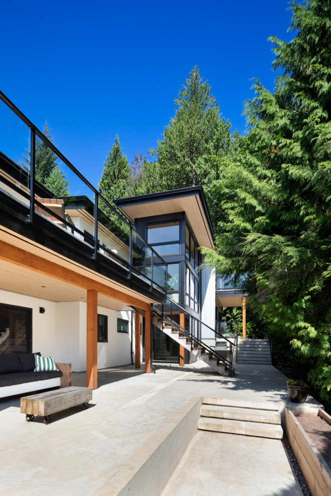 Inspiration for a large contemporary house exterior in Vancouver with mixed siding and a black roof.