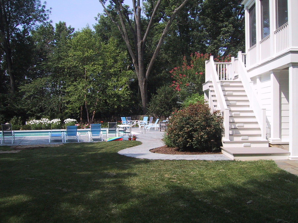 Example of a mid-sized transitional backyard stamped concrete and rectangular lap pool house design in Baltimore