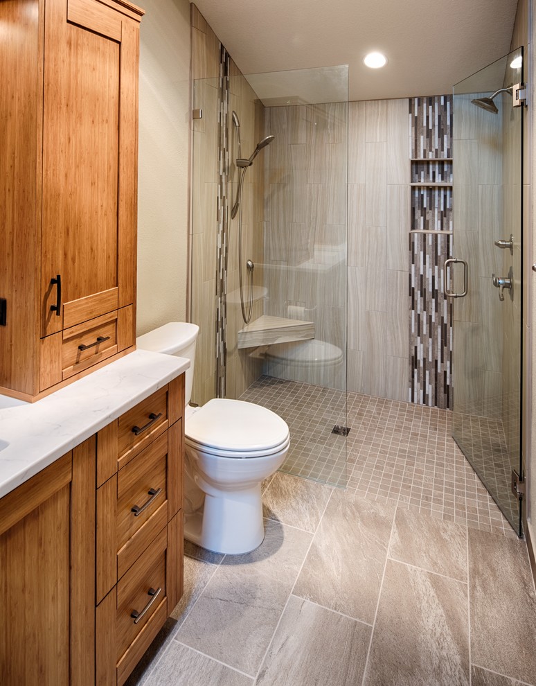 Inspiration for a mid-sized contemporary master bathroom in Portland with shaker cabinets, medium wood cabinets, a curbless shower, a two-piece toilet, beige tile, porcelain tile, beige walls, porcelain floors, an undermount sink, engineered quartz benchtops, beige floor, a hinged shower door and beige benchtops.