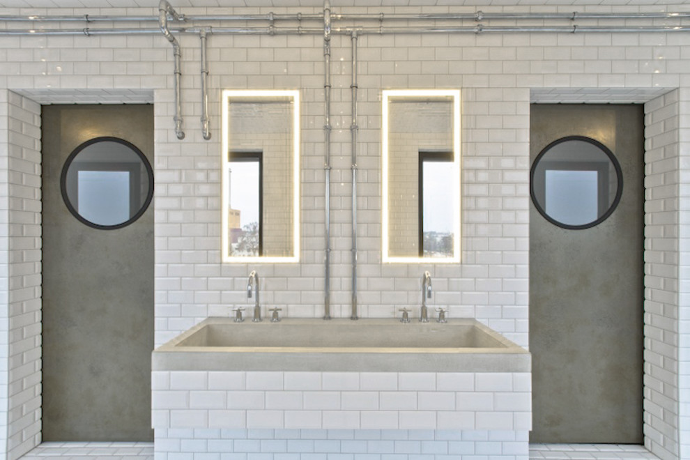 Photo of a large industrial bathroom in Berlin with flat-panel cabinets, white tile, subway tile, white walls, ceramic floors and a drop-in sink.