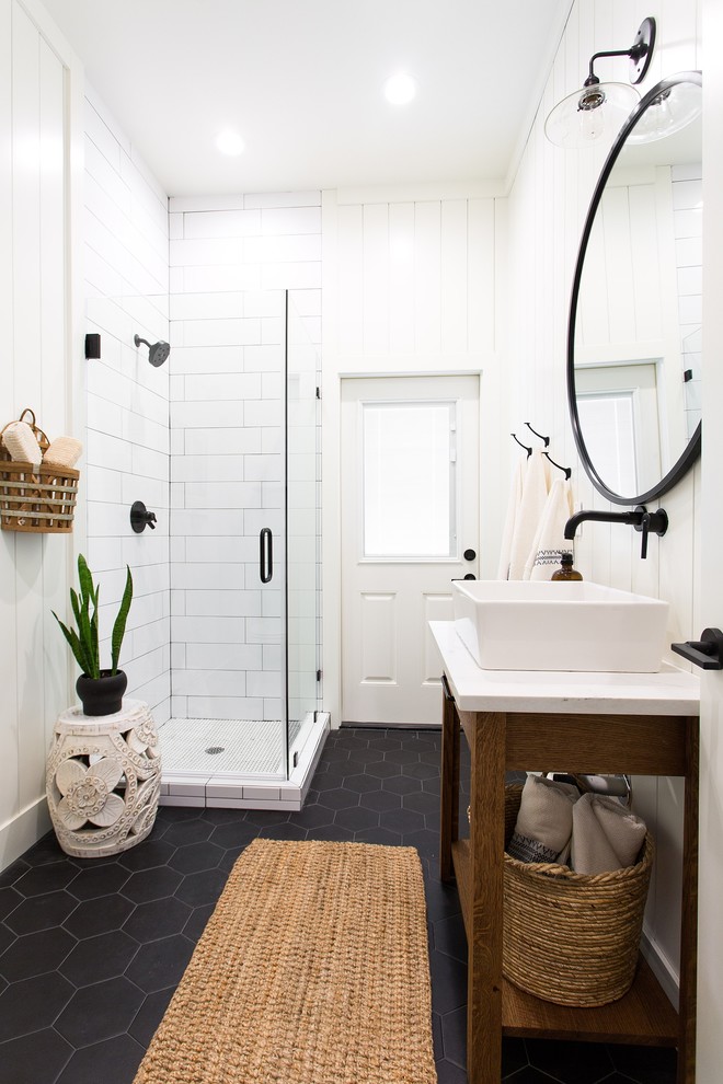 Design ideas for a transitional bathroom in Sacramento with medium wood cabinets, a corner shower, white tile, white walls, a vessel sink, black floor, a hinged shower door, white benchtops and open cabinets.