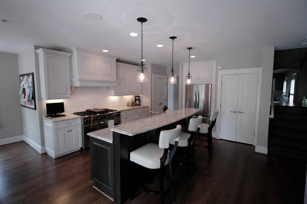 Open concept kitchen - mid-sized transitional galley dark wood floor open concept kitchen idea in DC Metro with an undermount sink, raised-panel cabinets, white cabinets, granite countertops, white backsplash, ceramic backsplash, stainless steel appliances and an island